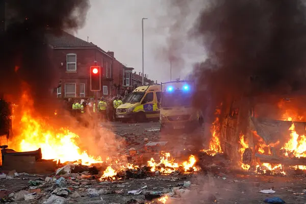 Police van burnt as killings spark riot in UK